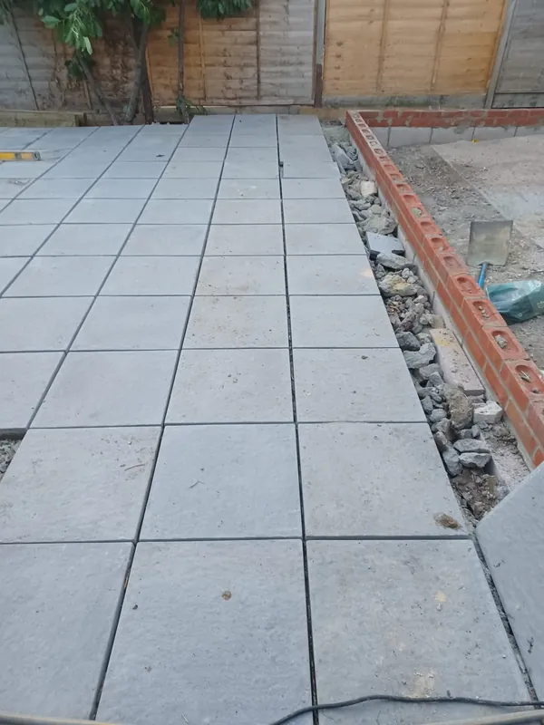 New brick wall going up beside the paving