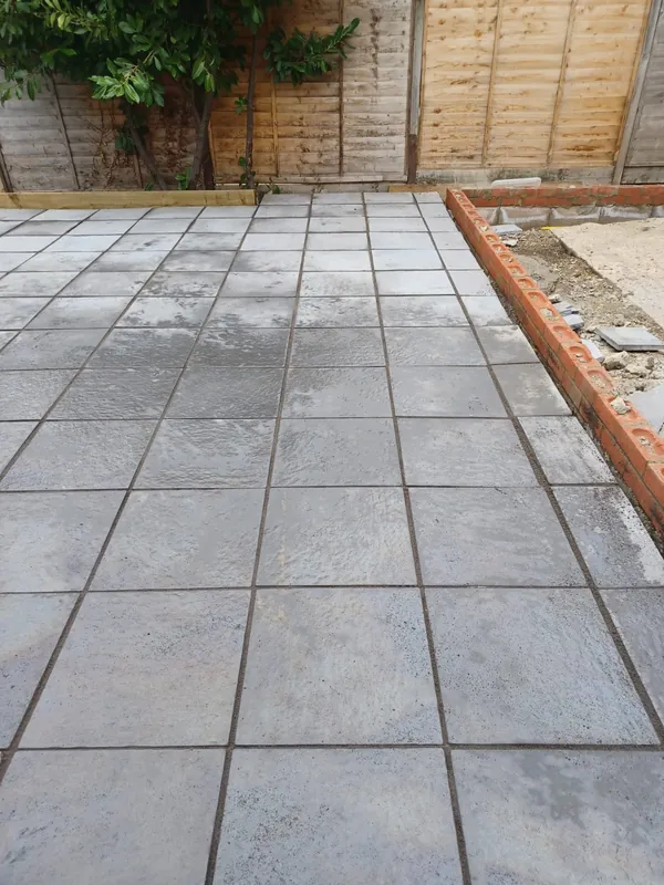 Finished patio meeting a new red brick wall